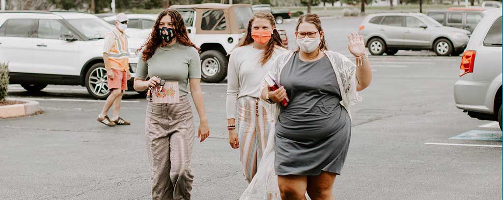 Three women in masks walking into church